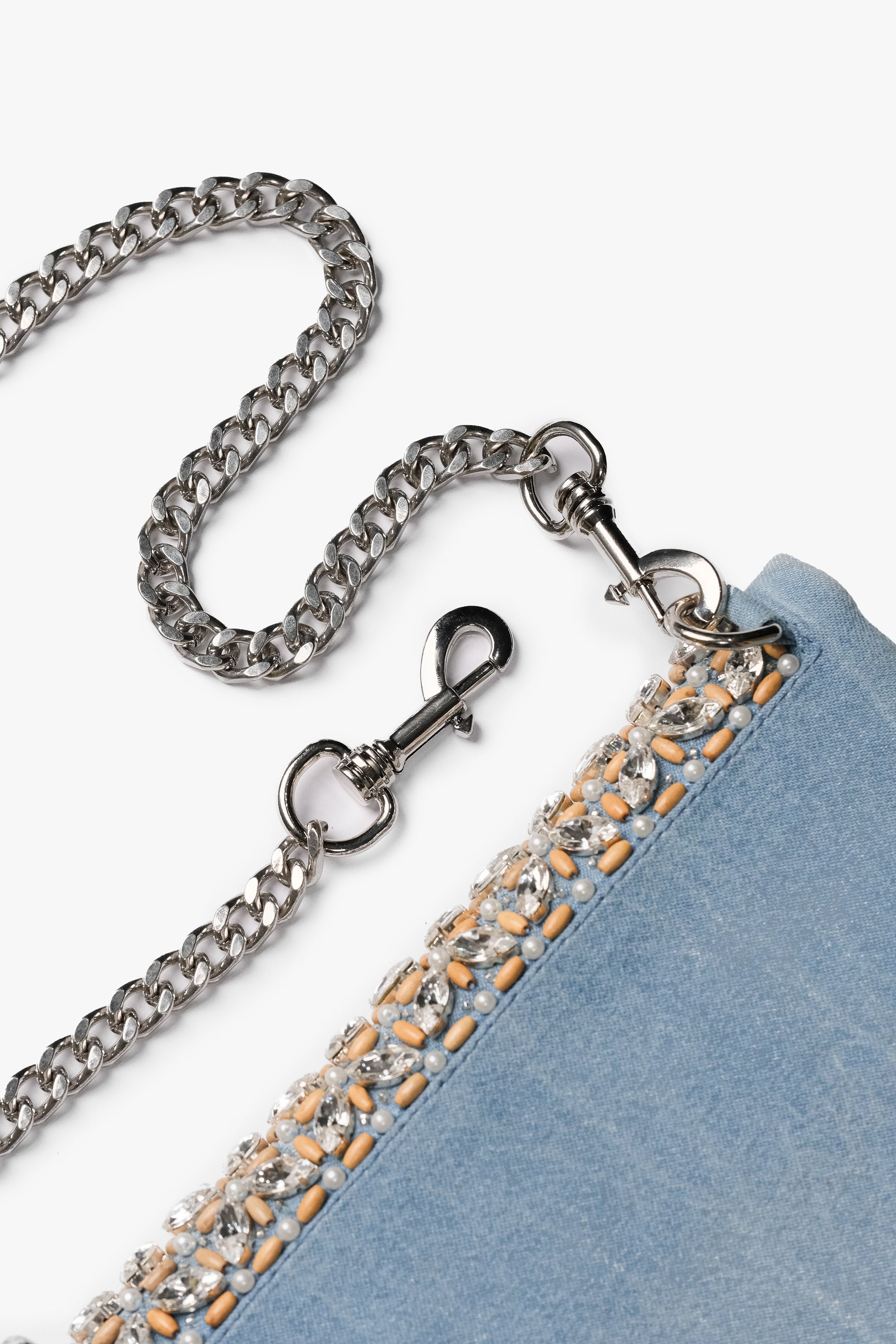 Acambha's Crystal Bead Glam Clutch features delicate crystal beading, pearls, and wooden beads, with a zipper and magnet button on the flap. This clutch showcases meticulous craftsmanship.