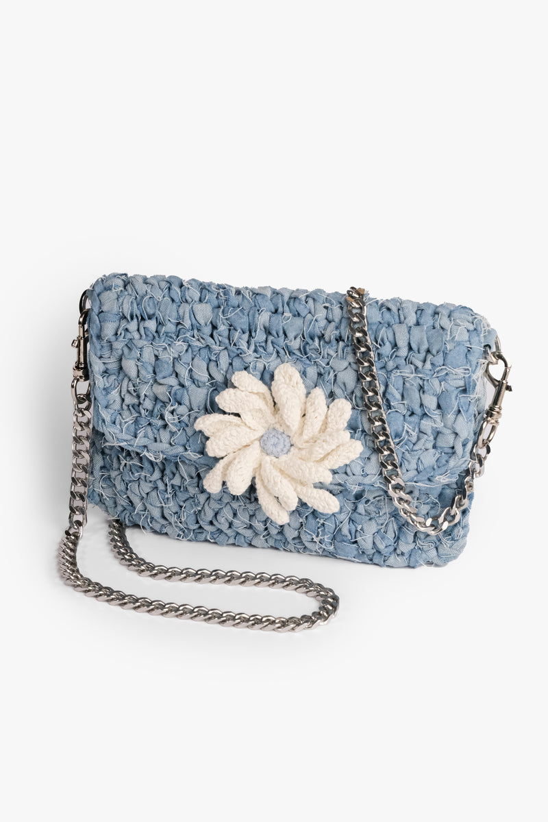 Daisy Denim Crochet Clutch made from upcycled denim strips with a press stud closure. Features a crochet flower and frayed design