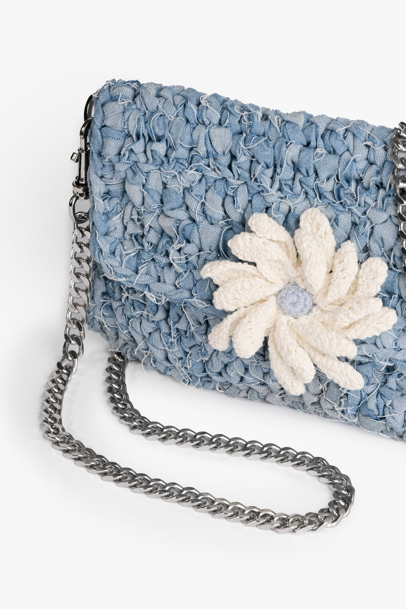 Daisy Denim Crochet Clutch made from upcycled denim strips with a press stud closure. Features a crochet flower and frayed design