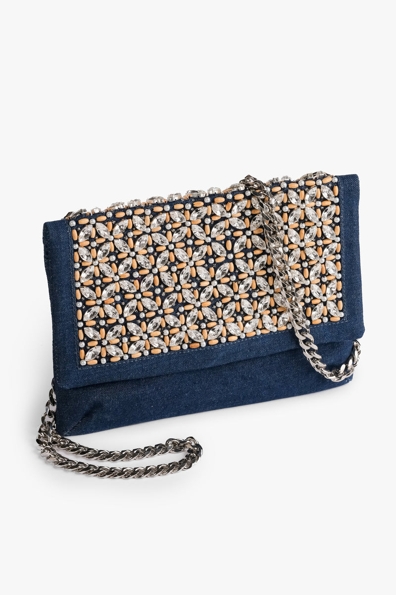 Acambha's Crystal Bead Glam Clutch  features delicate crystal beading, pearls, and wooden beads, with a zipper and magnet button on the flap. This clutch showcases meticulous craftsmanship.